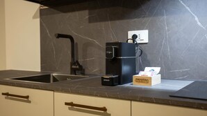 A kitchen with a coffee maker, a box of coffee pods, and a water dispenser. - Ca Moroni Collection (Bergamo)