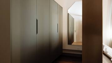 A room with a large wardrobe, a wooden floor, and a ceiling with exposed beams.