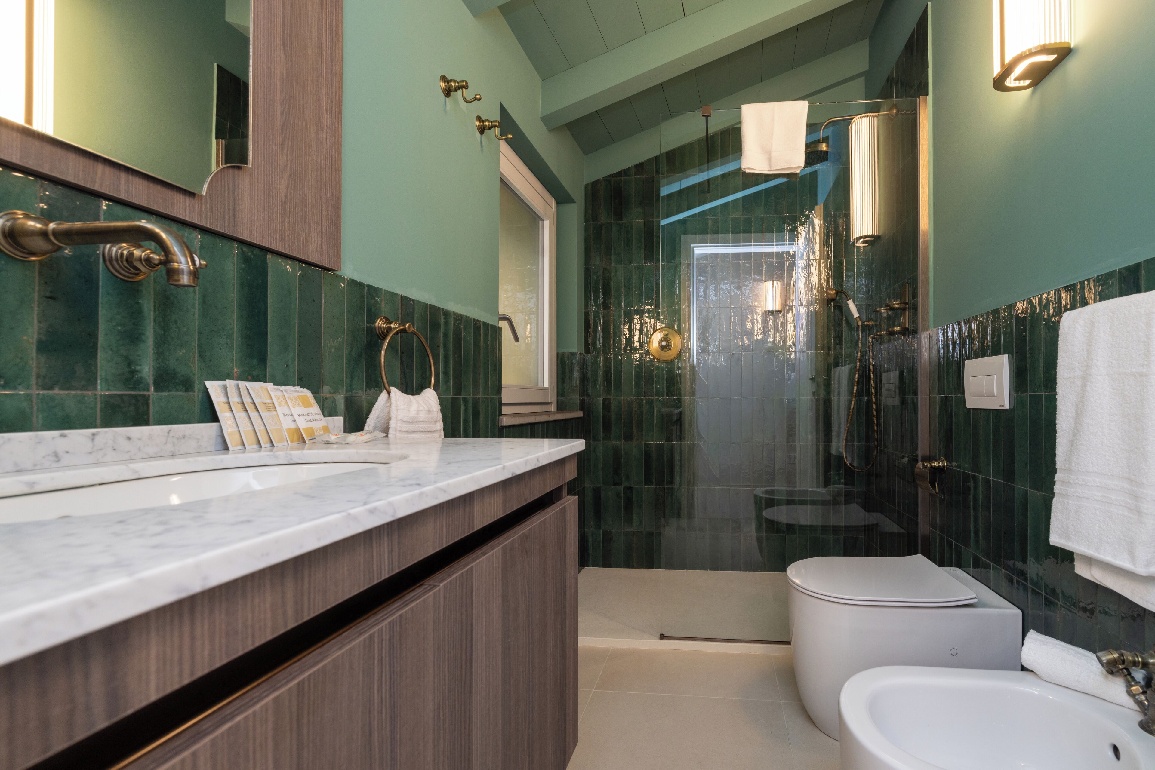 Un bagno moderno con un mobile vanitario in marmo, cabina doccia in vetro e servizi igienici.