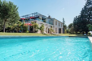 Piscina a l'aire lliure de temporada, para-sols i gandules 