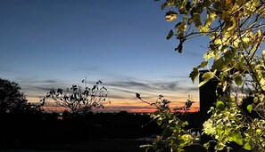 A sunset view with silhouettes of trees and buildings. - DOMAINE DE LA PEYRINE (Carignan-de-Bordeaux)