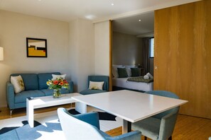 Una sala moderna con un sofá, una mesita de centro y una mesa de comedor.