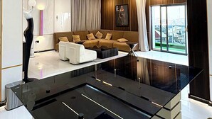 A modern living room with a central island, a sofa, and a large window offering a view. - Rahat luxury apartment (Lagos)