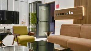 A modern hotel room with a sofa, armchair, and a glass coffee table. - Rahat luxury apartment (Lagos)