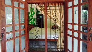 A wooden door with glass panels and decorative metalwork. - Keerthi Homestay (Sigiriya)