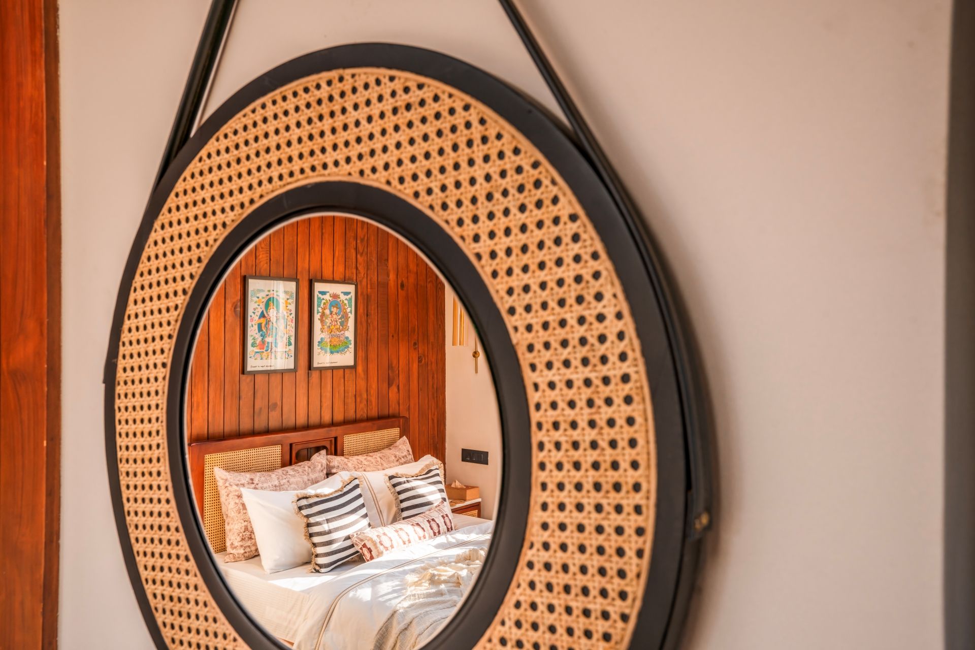 A circular mirror with a wooden frame and a rattan-like texture.