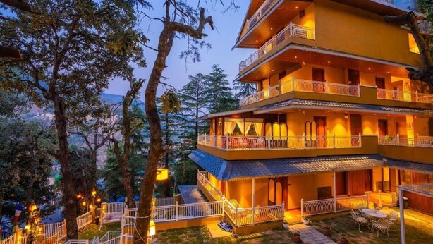 Ein mehrstöckiges Hotel mit Balkonen, Außenbereich und Blick auf die umliegende Landschaft.