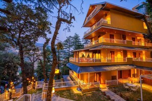 Un hôtel à plusieurs étages doté de balcons, d’un espace extérieur aménagé et offrant une vue sur le paysage environnant.