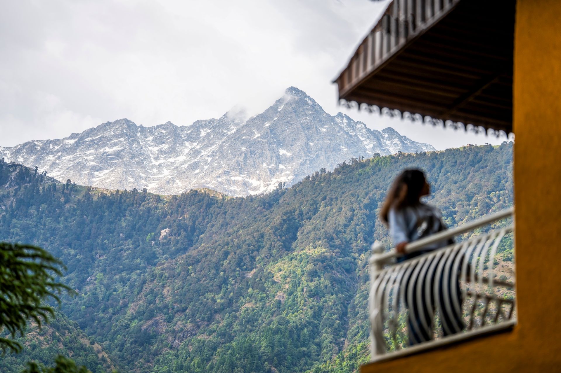 Une vue sur une montagne avec une personne sur un balcon.