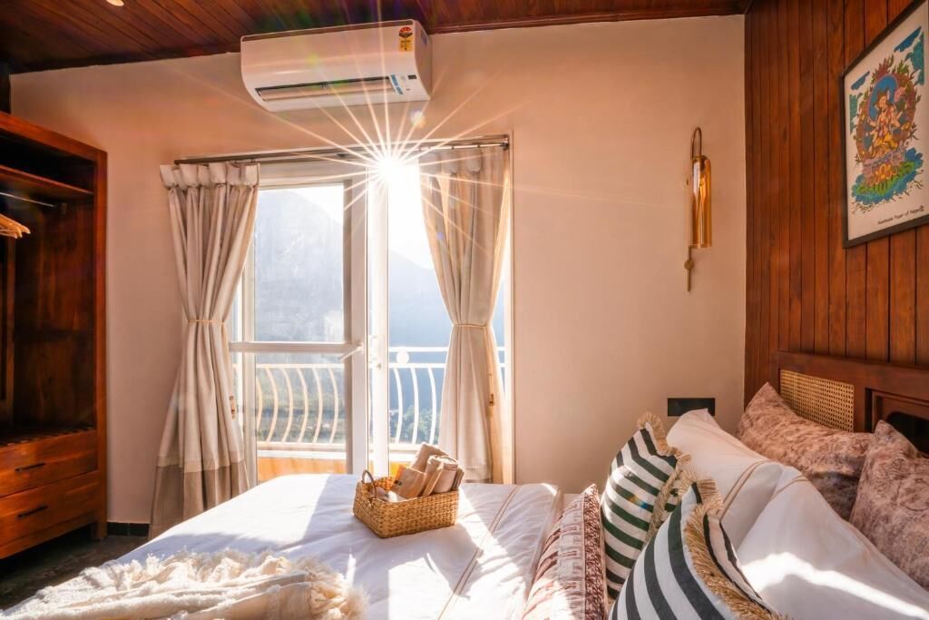Un dormitorio con cama, ventana con cortinas, lámpara de pared e imagen enmarco.