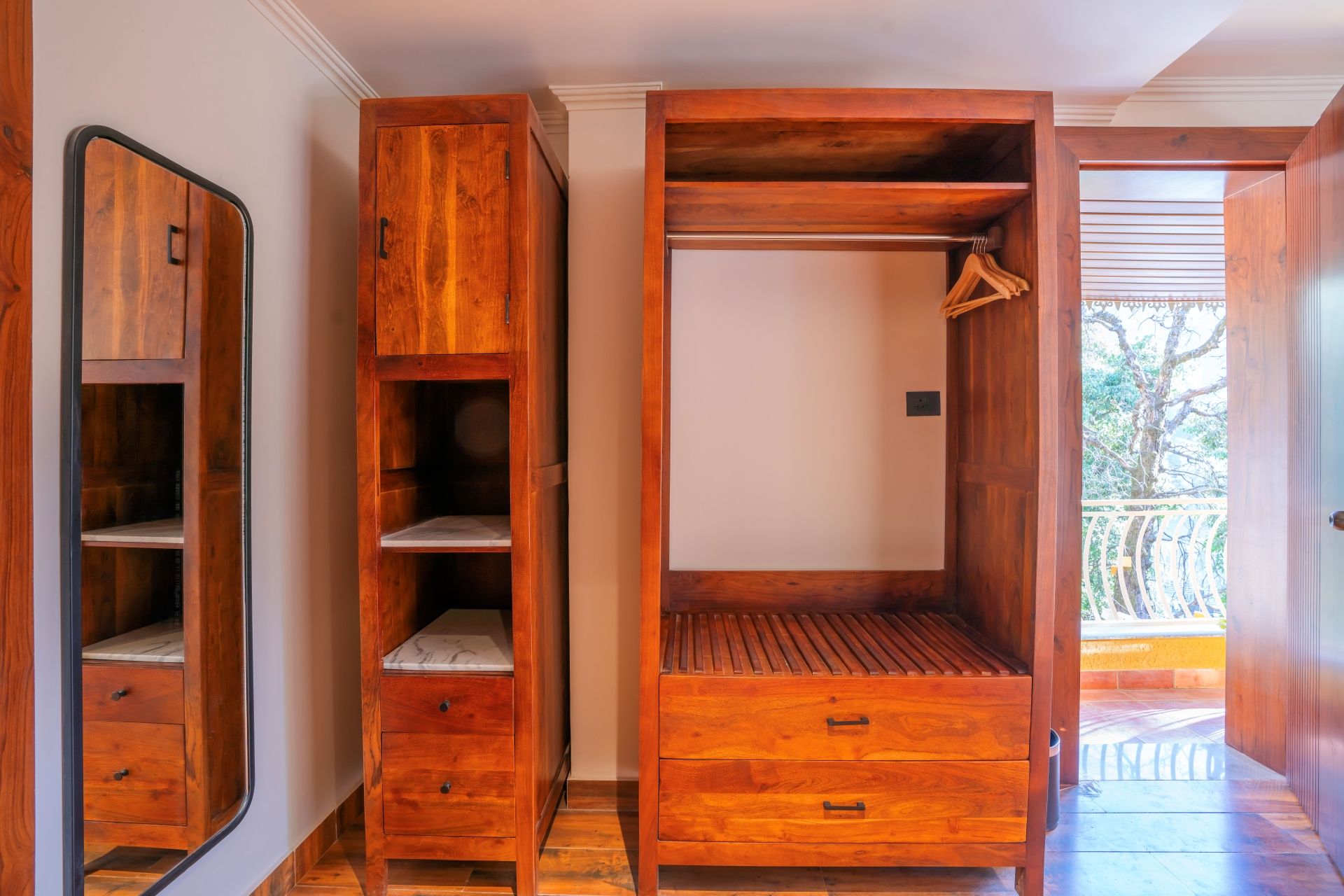 A wooden wardrobe with multiple compartments and a hanging space.