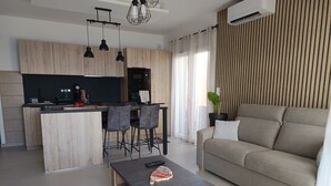 Un espacio habitable moderno con cocina, comedor y sofá.