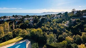 Un quartier résidentiel doté d’une piscine, entouré d’une végétation luxuriante et de maisons.