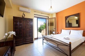 Ein Schlafzimmer mit Bett, Kleiderschrank und angrenzendem Badezimmer, das durch eine offene Tür sichtbar ist.