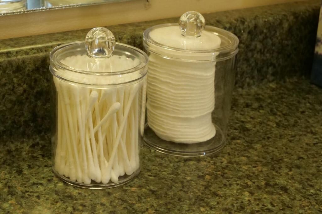 Two glass jars with lids on a granite countertop.