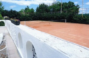 Ein Tennisplatz mit weißer Wand und Netz.