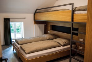 A bunk bed with a wooden frame and a window with curtains. - Rackésmillen (Enscherange)