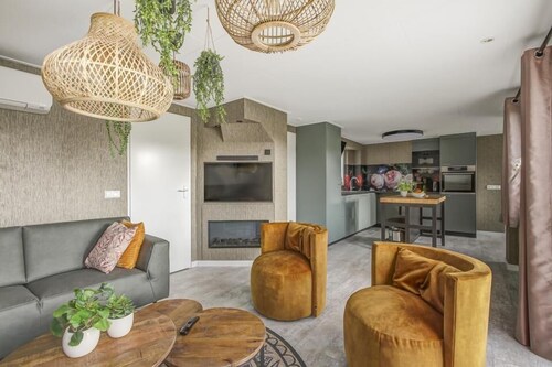 Modern family home for 10 people with 5 bedrooms, 2 bathrooms (one with sunshower), and a spacious garden on the edge of the forest at Holiday Park 't Hooge Holt.