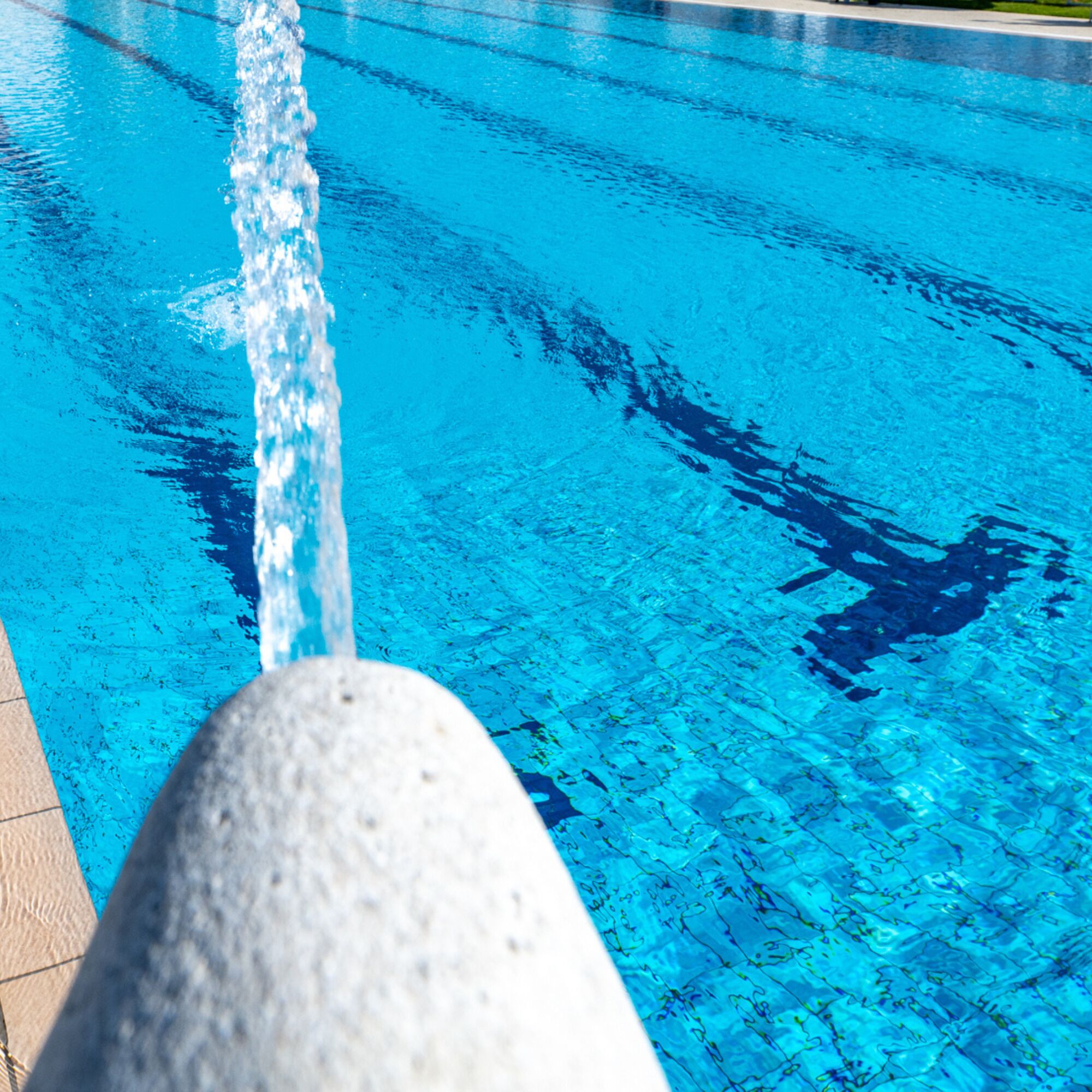 Ein klarer, blauer Pool mit einer Steinkante.