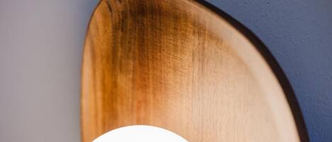 Un objet en bois, fixé au mur, doté d’une lumière circulaire blanche.