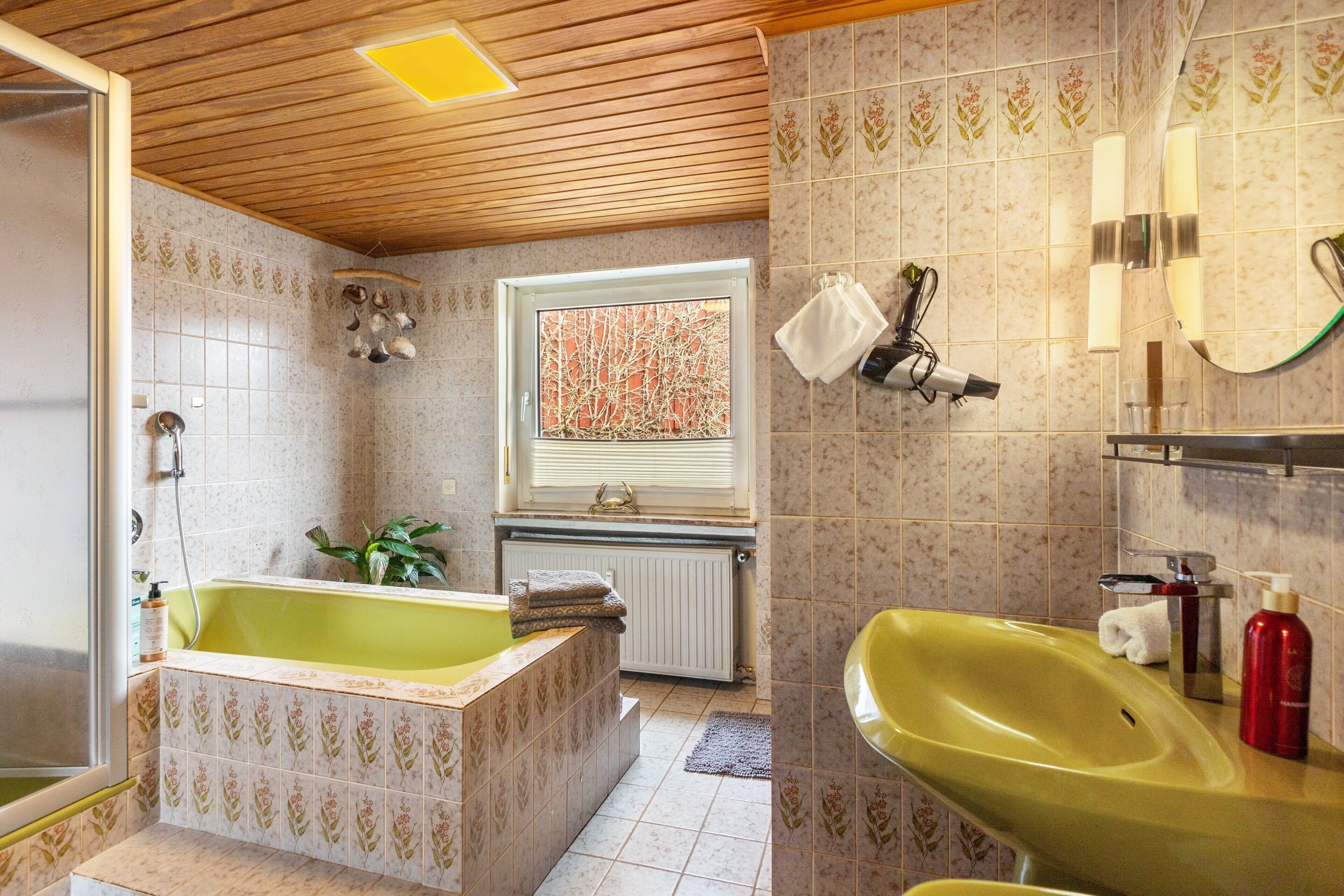 A bathroom with a bathtub, a sink, and a window.