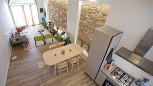 A compact kitchen with a dining area, a stone accent wall, and a view through a window.