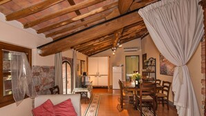 A cozy room with a bed, a dining table, chairs, a kitchen area, and a living space with a fireplace. - Tenuta San Giovanni Alloro (lucca)