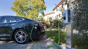 A car charging at a station with a building in the background. - Tenuta San Giovanni Grapefruit (Lucca)