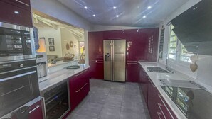 Una cocina moderna con electrodomésticos de acero inoxidable, un refrigerador y un lavamanos.