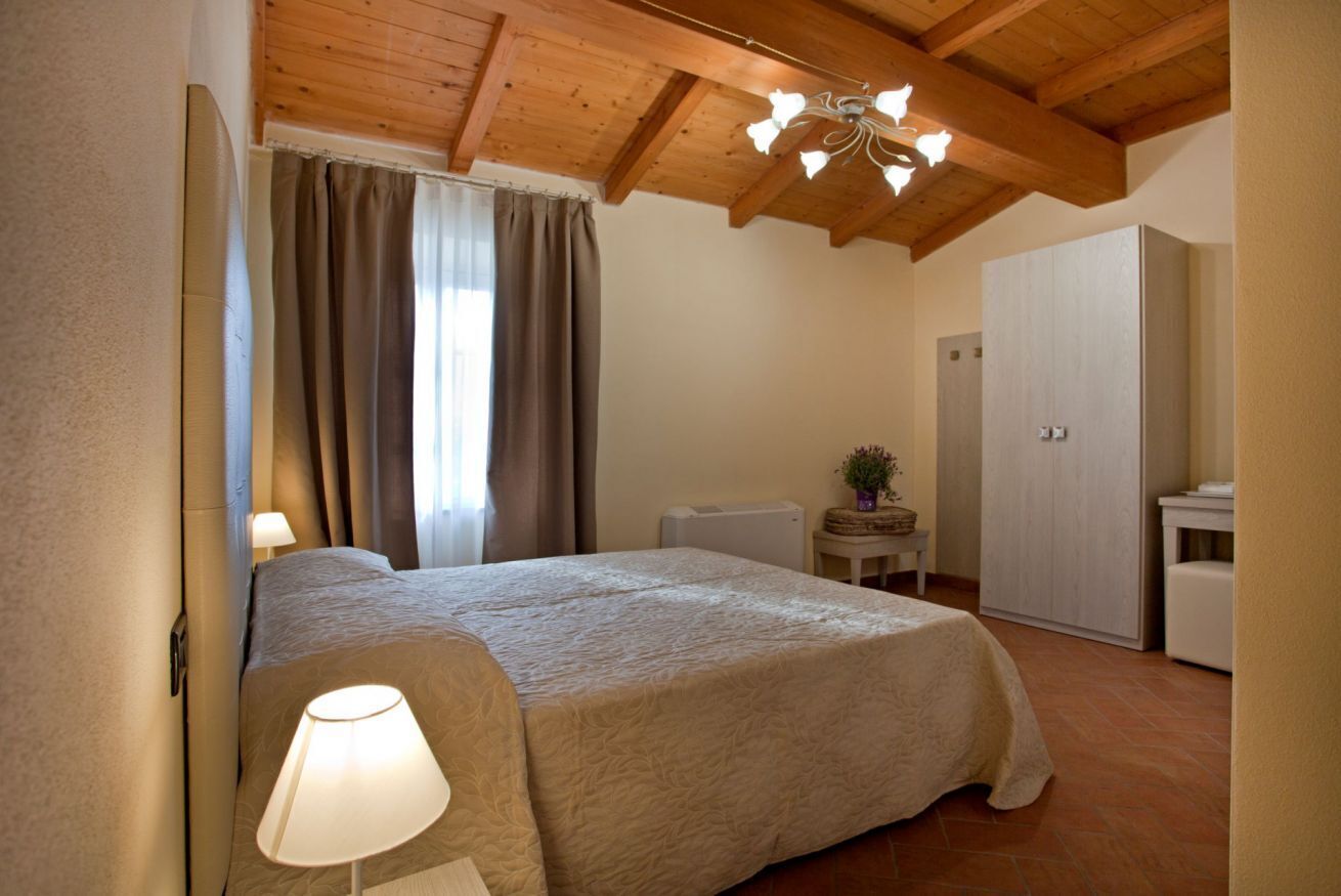 Ein Schlafzimmer mit einem Bett, einer Lampe, einem Deckenventilator, einem Heizkörper und einem Kleiderschrank.