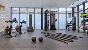 A modern gym with cardio equipment, free weights, and a punching bag. - For Students Only Ensuites in Coventry (Coventry)