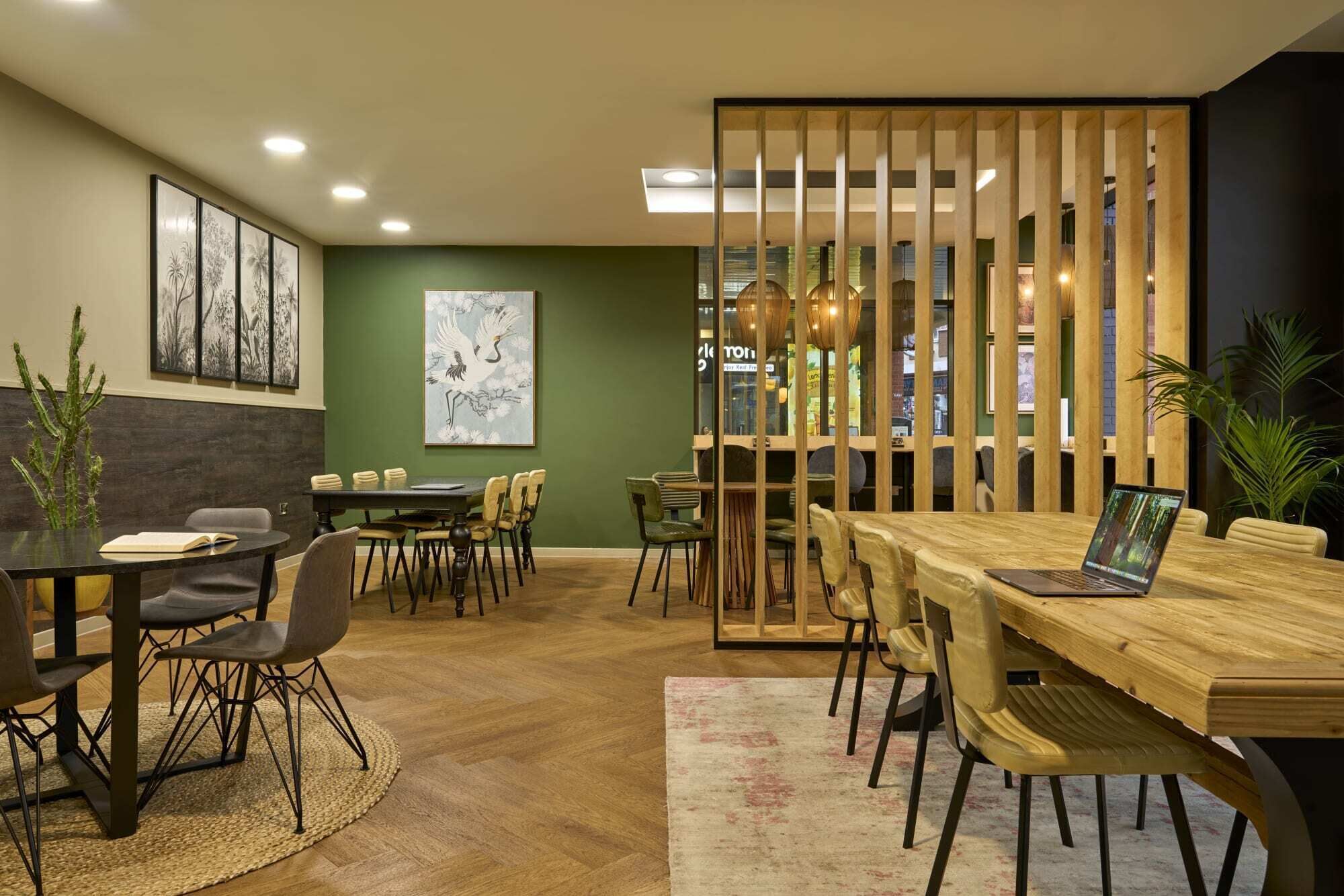 A modern meeting room with a wooden table, chairs, and a large painting on the wall.