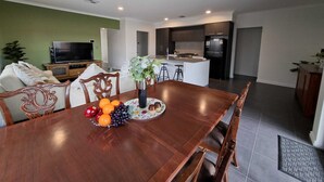Une cuisine moderne avec des meubles de couleur sombre, un îlot central et un four encastré.