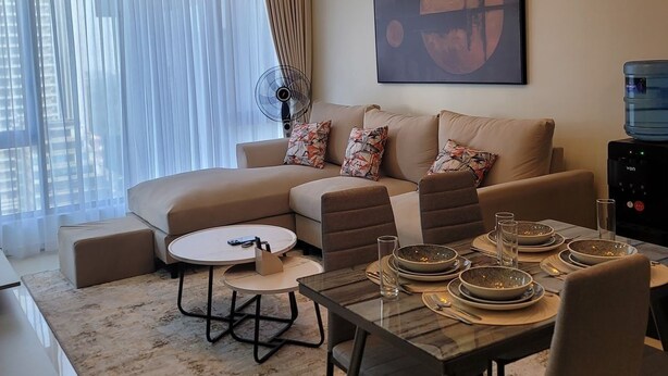 A modern living room with a sofa set, a dining table with chairs, and a large abstract painting on the wall. - Urban Nest Westlands – Infinity Pool, Gym & Scenic Views close to major malls (Nairobi)