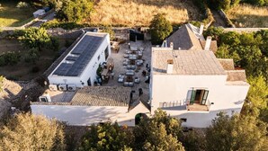 An aerial view of a property with a courtyard, a building with a sloped roof, and solar panels. - Masseria il Pergolo (Martina Franca)