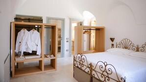 A bedroom with a bed, a wooden wardrobe, and a mirror. - Masseria il Pergolo (Martina Franca)