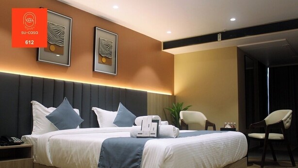 A modern hotel room with a large bed, bedside tables, a desk, and a chair. - The Belita Hotel Bhavnagar (Bhavnagar)