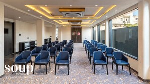 A conference room with rows of chairs, a patterned carpet, and modern ceiling lighting. - The Belita Hotel Bhavnagar (Bhavnagar)