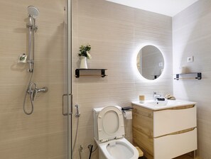 A modern bathroom with a shower, toilet, sink, and a mirror. - Apartment 'Casa Cantinho Da Touça' with Mountain View, Wi-Fi and Air Conditioning (Soajo)