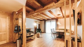 A spacious wooden interior with a dining area, seating, and a large mirror. - Regitnig‑Lake‑Hideaway am Weissensee (Weissensee)