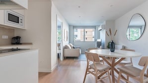 Eine moderne Küche mit Mikrowelle, Kaffeemaschine und einem Essbereich mit rundem Tisch und Stühlen.