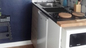 Eine kleine Küche mit Mikrowelle, Herd und Spüle.