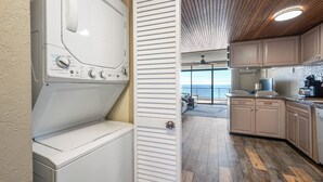 A laundry area with a washer and dryer, wooden cabinets, and a view of the ocean. - Spectacular Ocean Views from Lovely Condo with an Outdoor Pool (Ocean City)