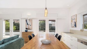 A modern dining area with a wooden table, chairs, a glass bowl, and a pendant light. - Peaceful 2BR Apt w/ Balcony by HolyGuest (Tel Aviv-Yafo)