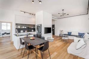 A modern living space with a dining area, kitchen, and seating area. - Contemporary 3BR Apt Near Geula Beach by HolyGuest (Tel Aviv-Yafo)