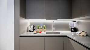 A modern kitchen with a stainless steel sink, a kettle, a blender, and a cutting board with vegetables. - Italianway Comfort - Vincenzo Monti 29 F (Milan)