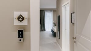 A hallway with a door labeled '2', a keypad, and a view into a bedroom with a bed and curtains. - Il Pumo Apulian Rooms Bari Calefati 141 (Bari)