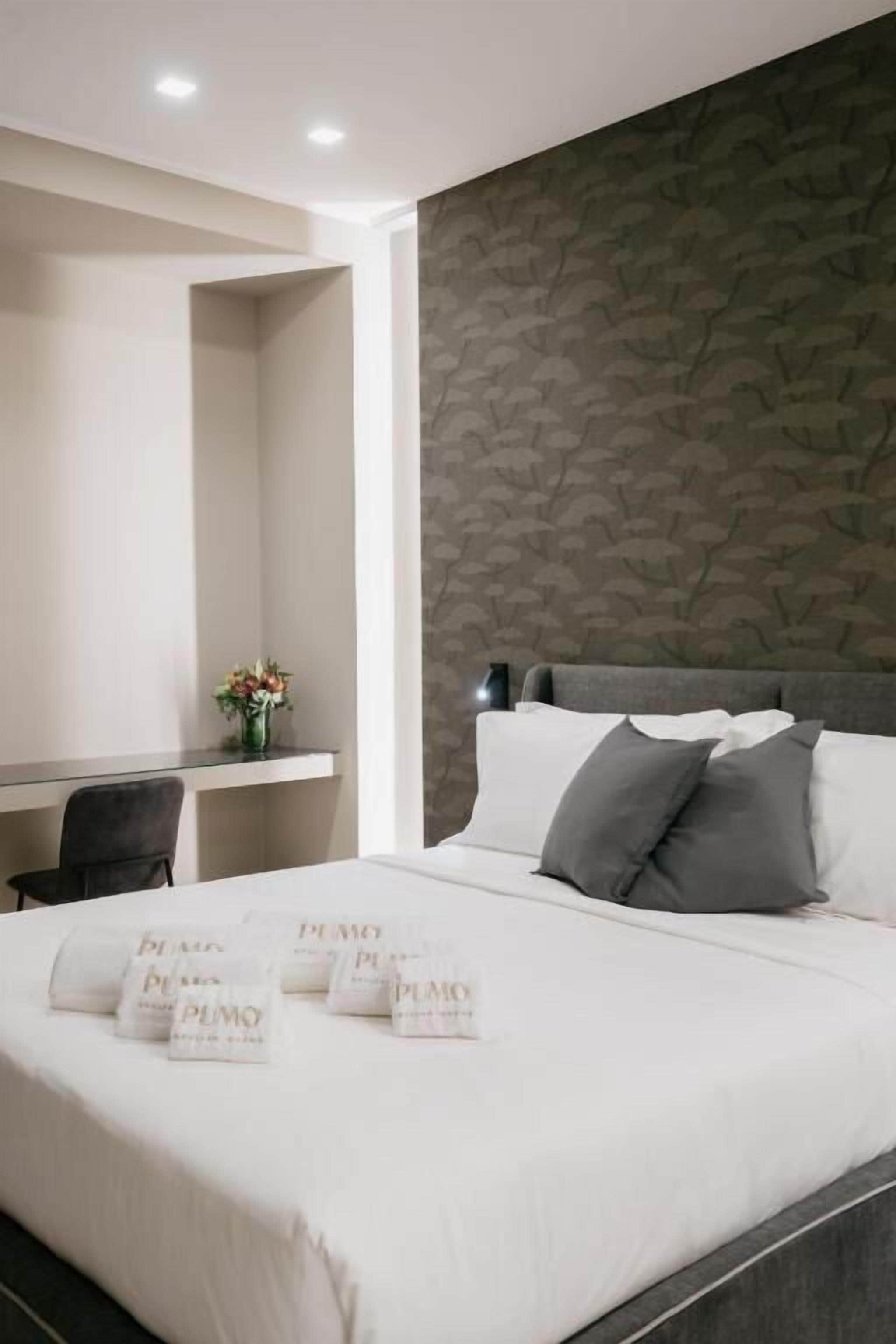 Une chambre d’hôtel avec un lit, un bureau et une chaise.