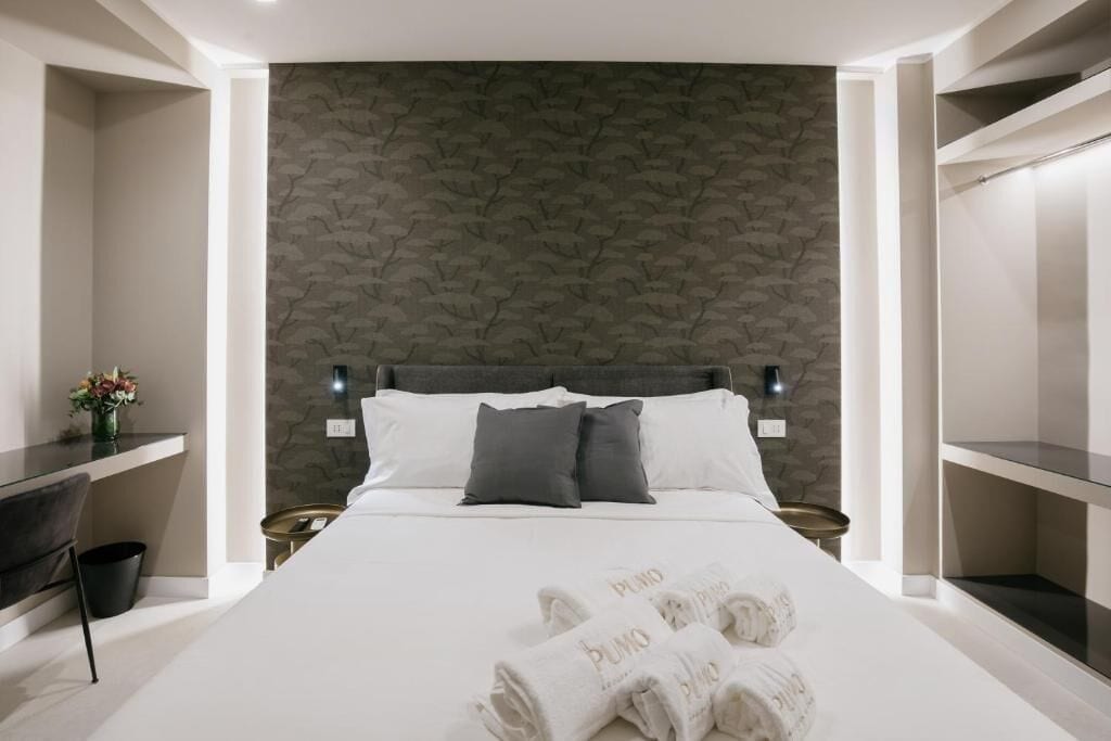 Ein modernes Hotelzimmer mit einem großen Bett, einem Schreibtisch und einem Kleiderschrank.
