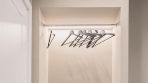 A closet with a hanging rack and a framed picture. - Il Pumo Apulian Rooms Bari Calefati 141 (Bari)